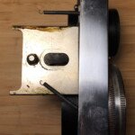 Right side of the lens panel. The springs provide some resistance when focusing and assist in pulling the panel in toward the body.