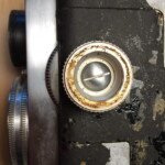 Close up view of left side and focusing knob. The cover is removed from the knob, revealing the screw that holds it on. Users could remove the knob if they desired.