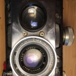 Front of the Reflex with the cocking and shutter levers removed, linking gear and aperture gear around viewing lens removed.